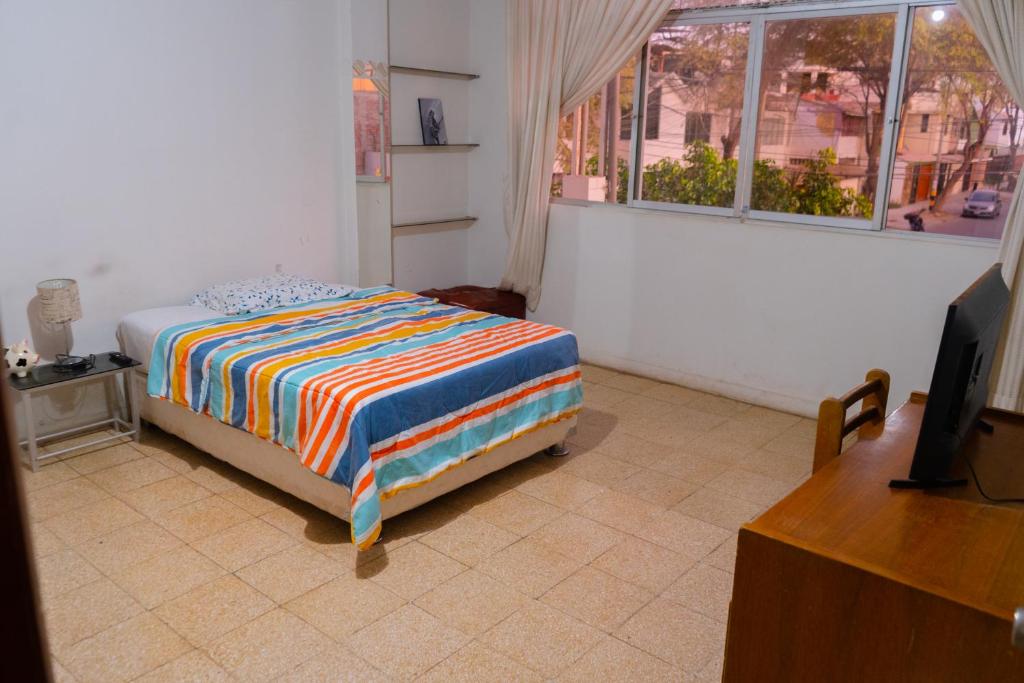 1 dormitorio con 1 cama en una habitación con ventana en Casa Pirhua, en Piura