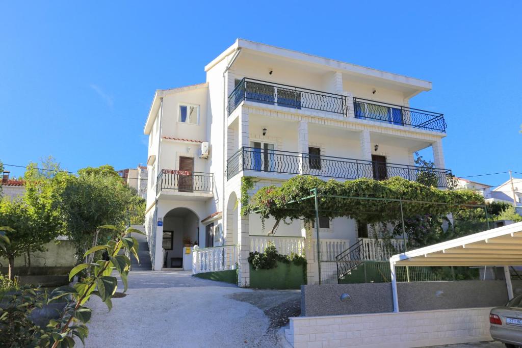 a white building with balconies on the side of it at Apartments by the sea Slatine, Ciovo - 9433 in Trogir