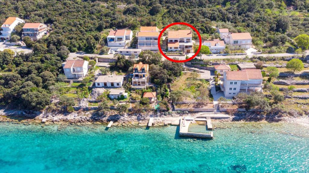 z góry widok na dom z łodzią w wodzie w obiekcie Apartments by the sea Tri Zala, Korcula - 9317 w Korčuli