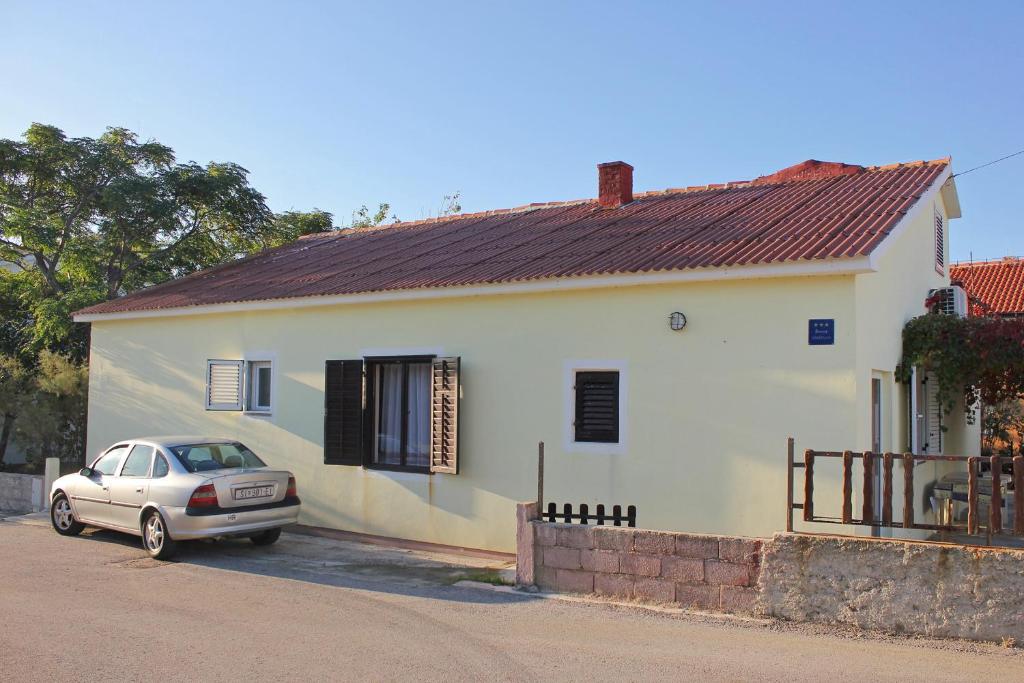 samochód zaparkowany przed białym domem w obiekcie Apartments with a parking space Povljana, Pag - 9353 w mieście Povljana