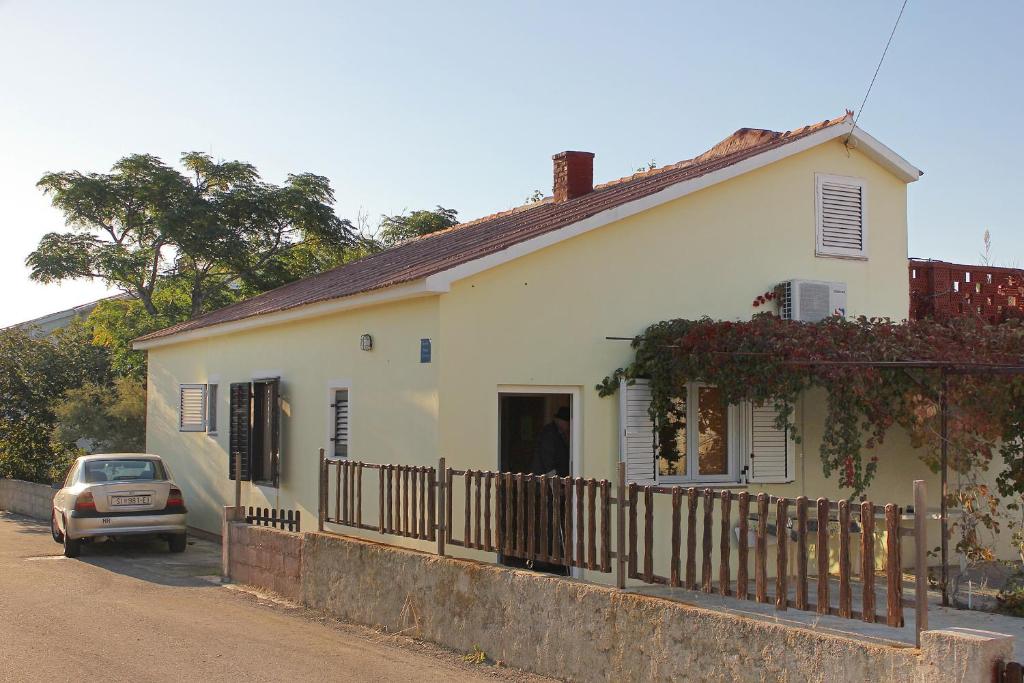 biały dom z zaparkowanym przed nim samochodem w obiekcie Apartments with a parking space Povljana, Pag - 9353 w mieście Povljana