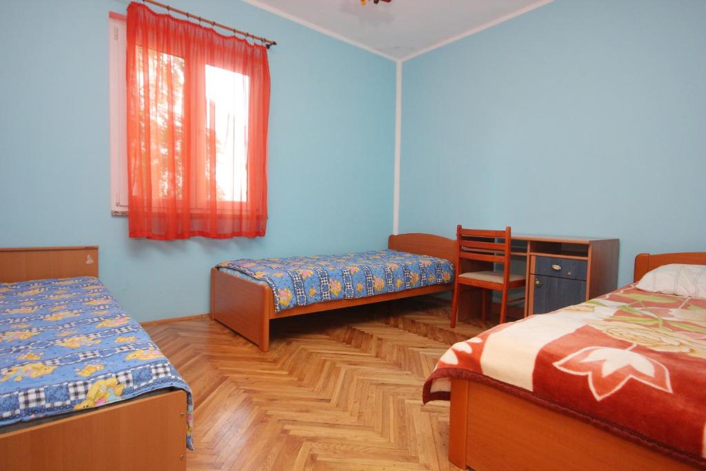 sypialnia z 2 łóżkami, biurkiem i stołem w obiekcie Apartments with a parking space Povljana, Pag - 9353 w mieście Povljana
