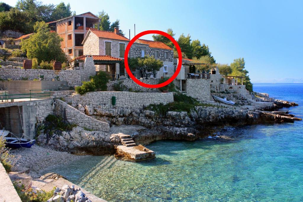 BabinaにあるSeaside secluded apartments Cove Danca - Babina, Korcula - 9322の水辺の家の上にある赤い円