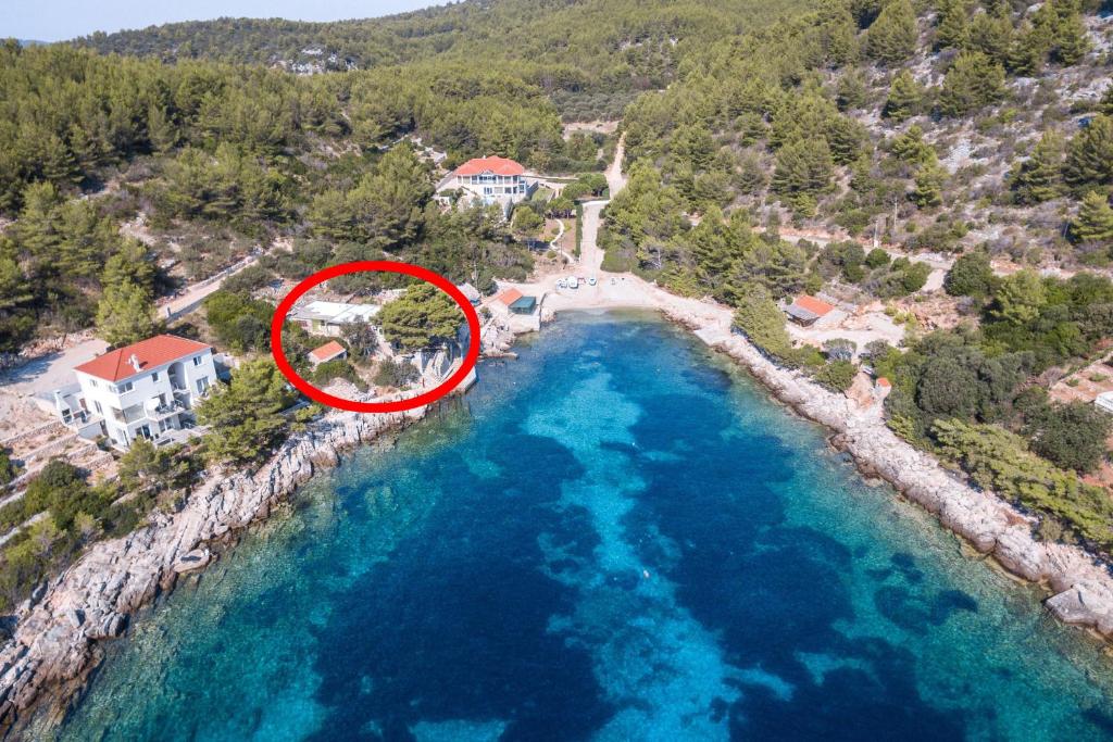 Vue aérienne d'une maison à côté d'une masse d'eau dans l'établissement Apartments by the sea Cove Zaglav, Korcula - 9320, à Prižba