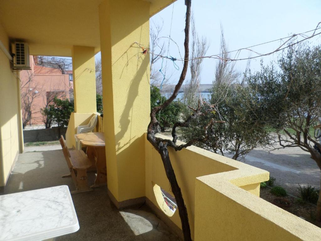 a yellow house with a table and a tree at Apartment Dinjiska 9386a in Povljana