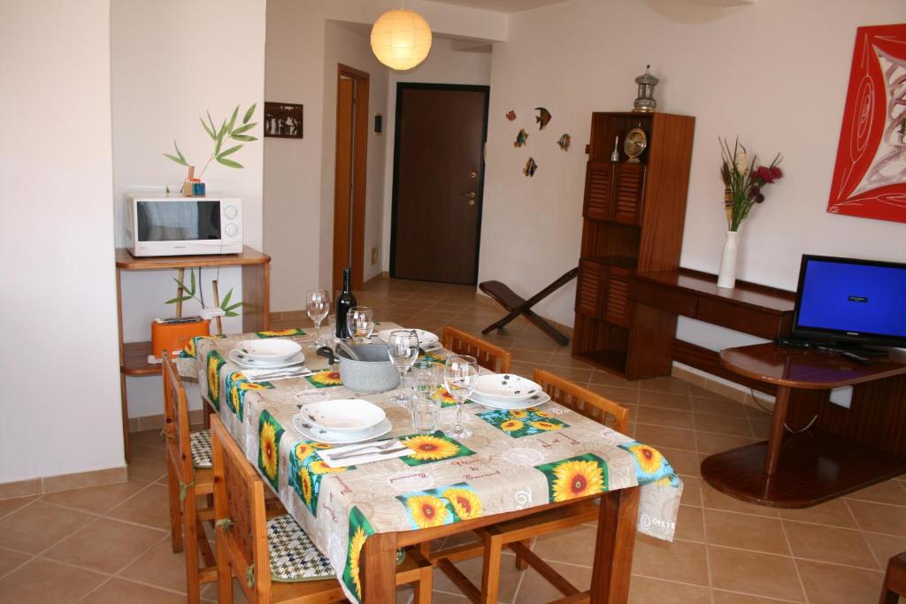 a dining room with a table with chairs and a laptop at Casa Bahia 5 in Santa Maria