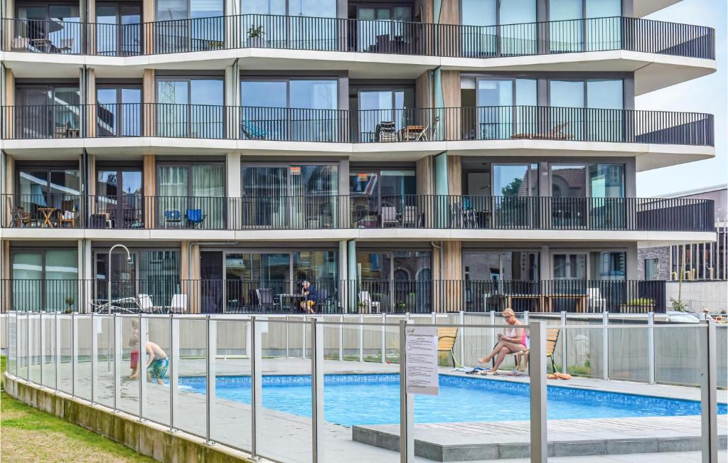 un edificio de apartamentos con piscina y gente en él en Residentie Crystal Ref 84, en Ostende