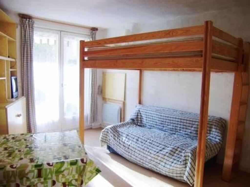 a bedroom with a bunk bed with a blue and white bedspread at Studio cabine 2 pers avec parking à Esquièze-Sère - FR-1-402-124 in Esquièze - Sère