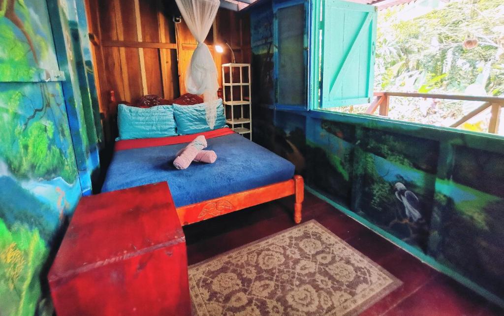 Habitación pequeña con cama y ventana en Hidden Jungle Beach House, en Puerto Viejo