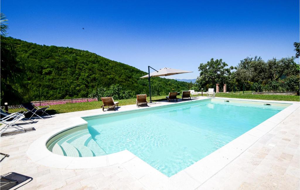 a large swimming pool with chairs and an umbrella at Beautiful Home In Loc, Spicciano With Outdoor Swimming Pool in Terenzano