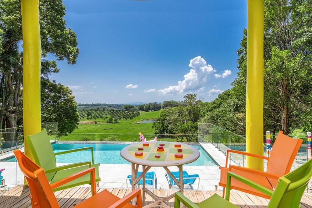 a patio with chairs and a table next to a pool at Donna's Art House in Alstonville