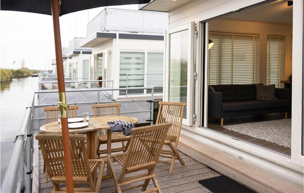 un porche con mesa y sillas en un barco en 2 Bedroom Cozy Ship In Aalsmeer, en Aalsmeer