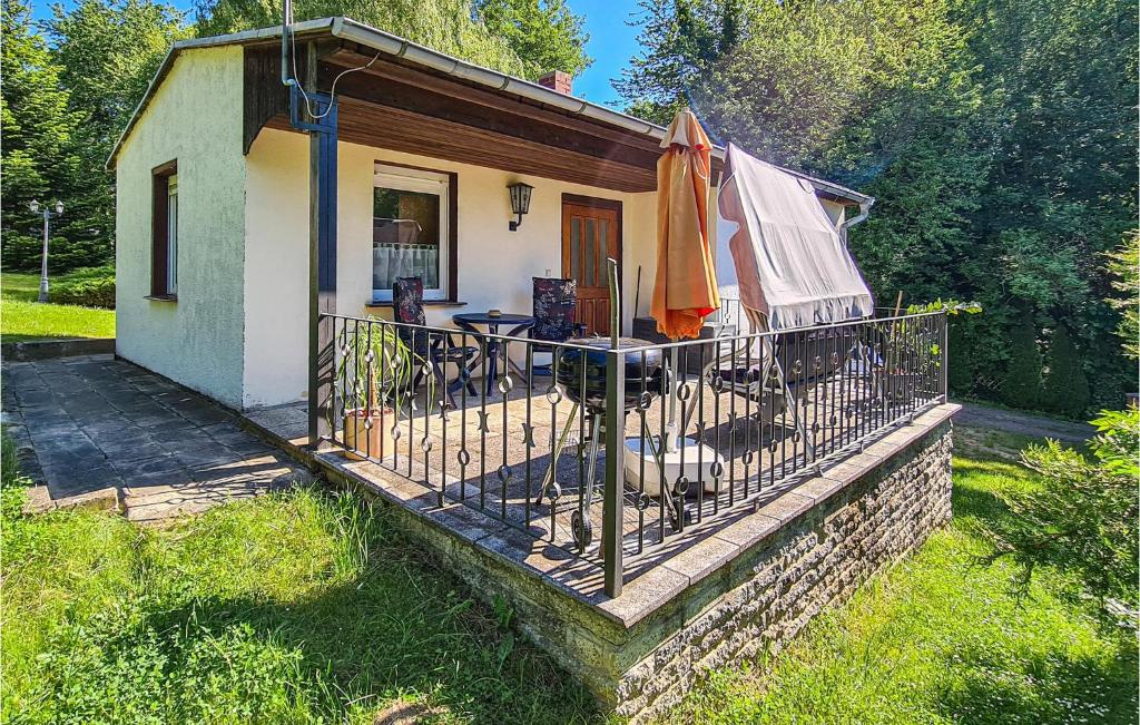 a small house with a balcony with a table and an umbrella at Nice Home In Harzgerode Ot D, With Wifi in Dankerode