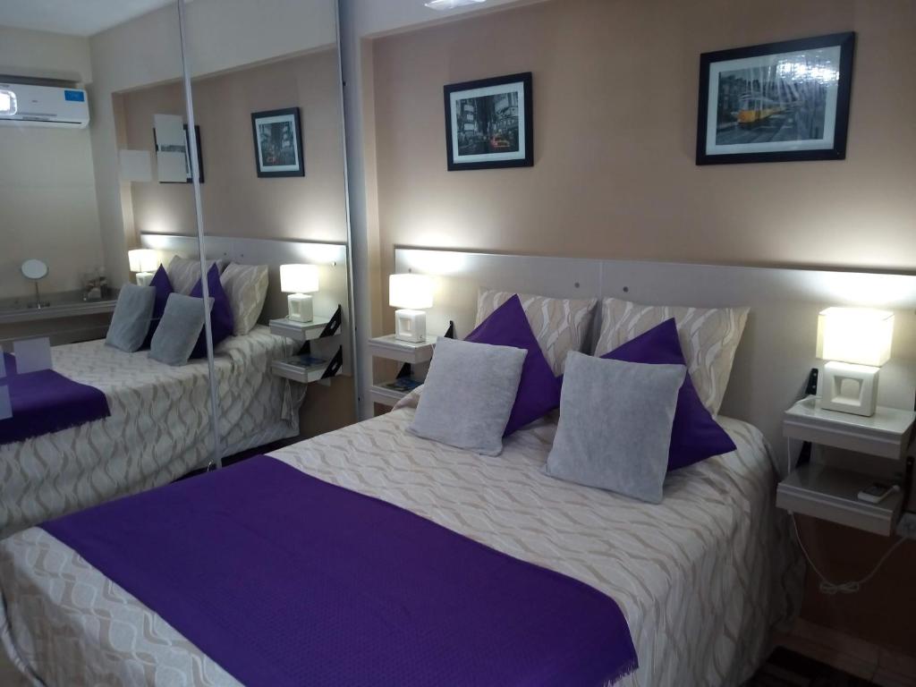 Habitación de hotel con 2 camas con almohadas moradas en Bello Departamento 2 Habitaciones, Barrio Norte en San Miguel de Tucumán