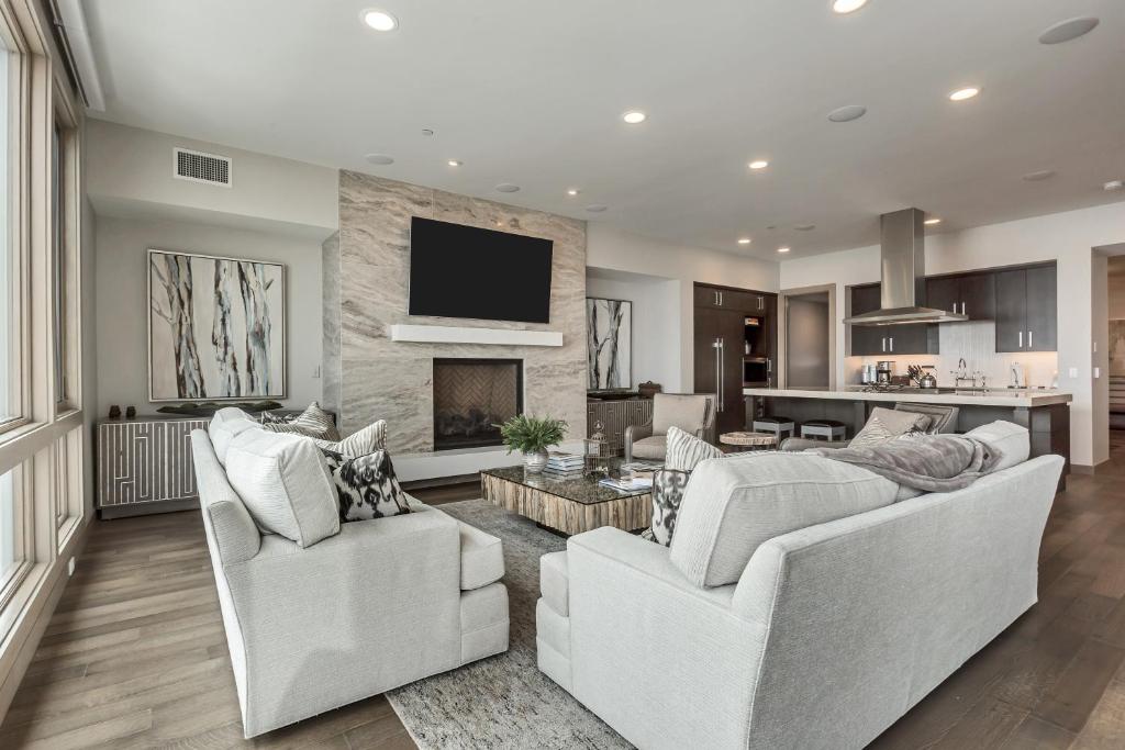 ein Wohnzimmer mit 2 weißen Stühlen und einem Kamin in der Unterkunft Premium Five Bedroom Suite apartment hotel in Park City