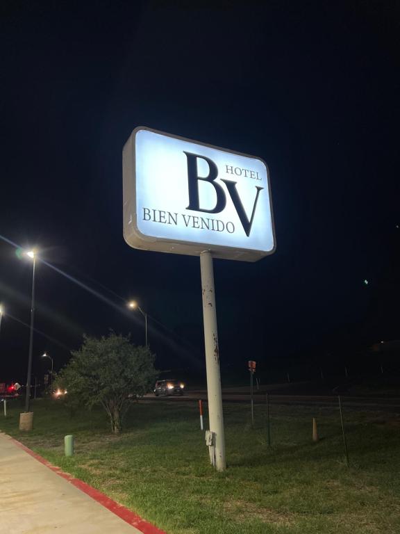 un cartello per un bvyben veronica in una strada di notte di Hotel Bien Venido a Pearsall
