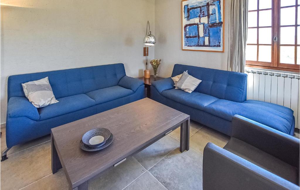 a living room with blue couches and a coffee table at Lovely Home In St Maurice Sur Eygues in Saint-Maurice-sur-Eygues