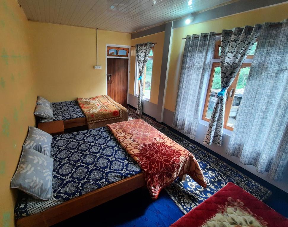 een slaapkamer met 2 bedden en een raam bij The Swarna Homestay in Darjeeling