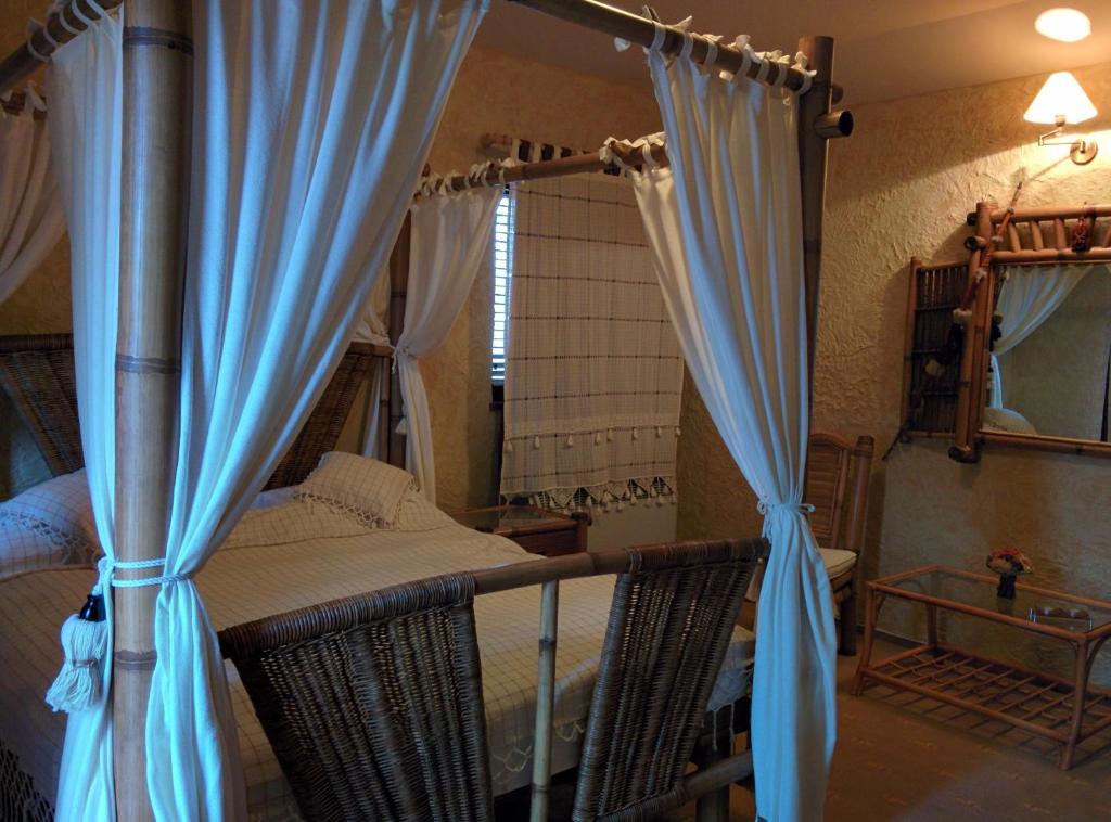 a bedroom with a canopy bed with blue curtains at Anette Resort & SPA in Covaci