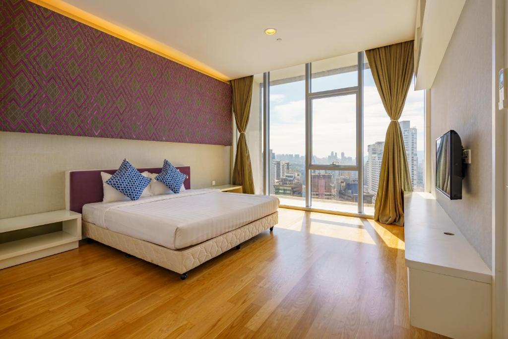 吉隆坡Yemala Suites at Platinum KLCC的一间卧室，里面有一张床和一扇大窗户。