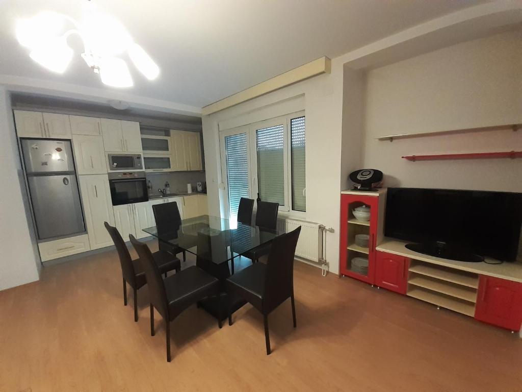 a dining room with a glass table and black chairs at Apartman Nole 1 in Despotovac