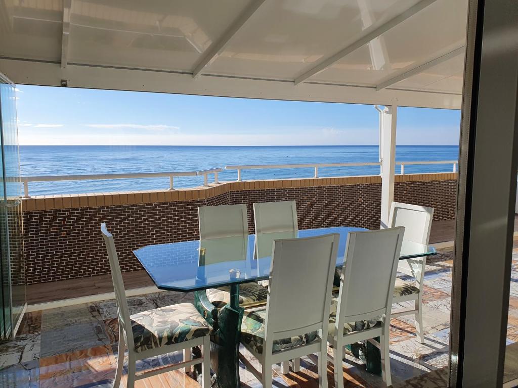 una mesa y sillas en un balcón con vistas al océano en Ático frente al mar. Apartamento TOP, en Oropesa del Mar