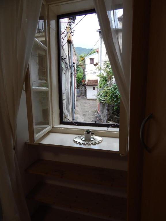 an open window with a vase sitting on a window sill at Old Town suite in Lovran