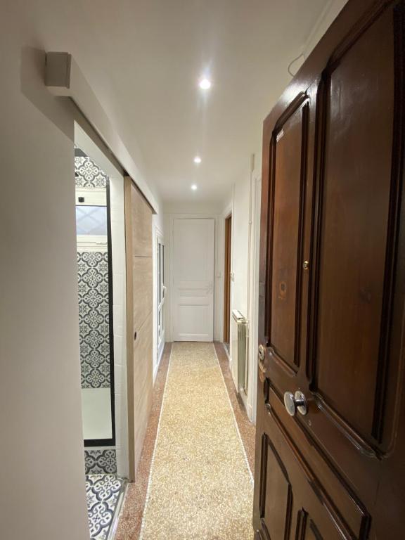 a hallway with a wooden door and a mirror at Nice port : cosy appartement au calme in Nice