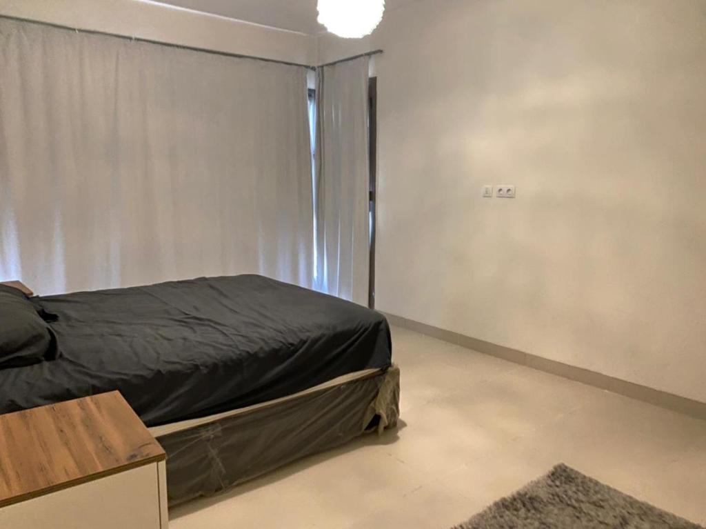 a small bedroom with a bed and a window at Apartment Marassi in El Alamein