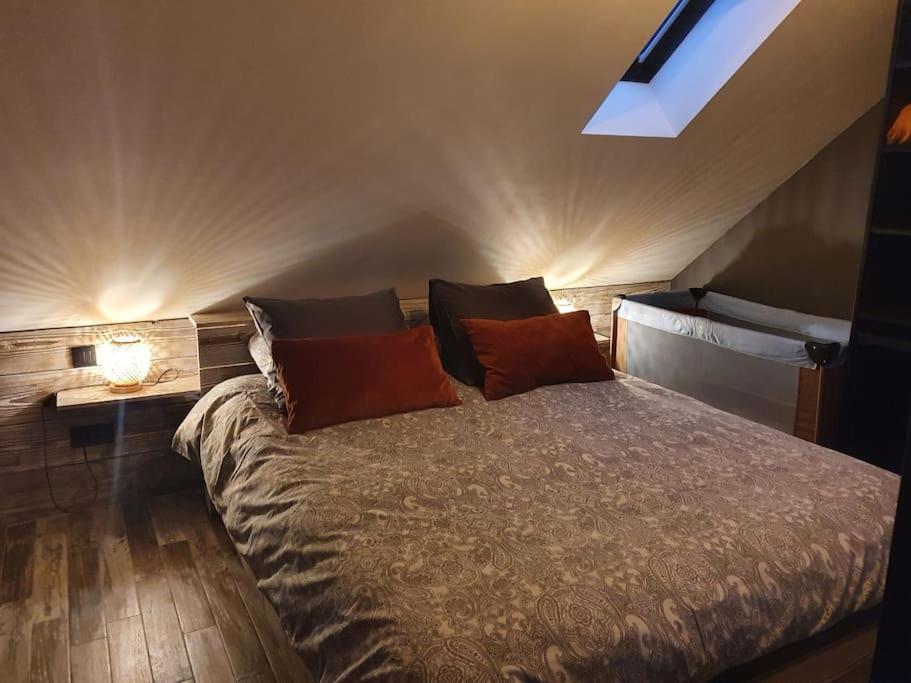 una camera da letto con un letto con cuscini sopra di Le Haut' Mont a Manhay