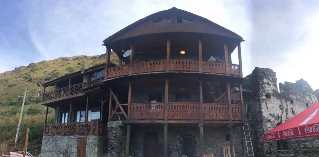 ein großes Gebäude mit einem Balkon auf einem Berg in der Unterkunft Qaldea Resort in Uschguli