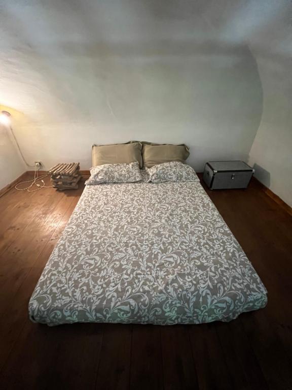 duże łóżko w pokoju z drewnianą podłogą w obiekcie B&B Da Dodo' w mieście Calizzano
