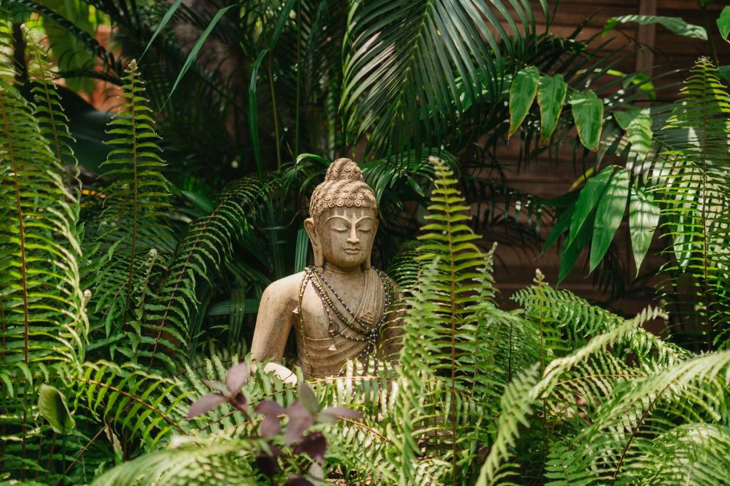Una statua in mezzo a un giardino di Mojigao ad Assagao