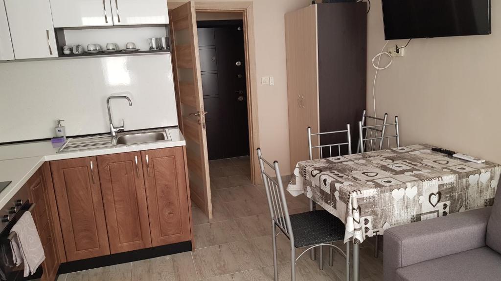 een kleine keuken met een tafel en een wastafel bij Апартамент за гости Ива in Ruse