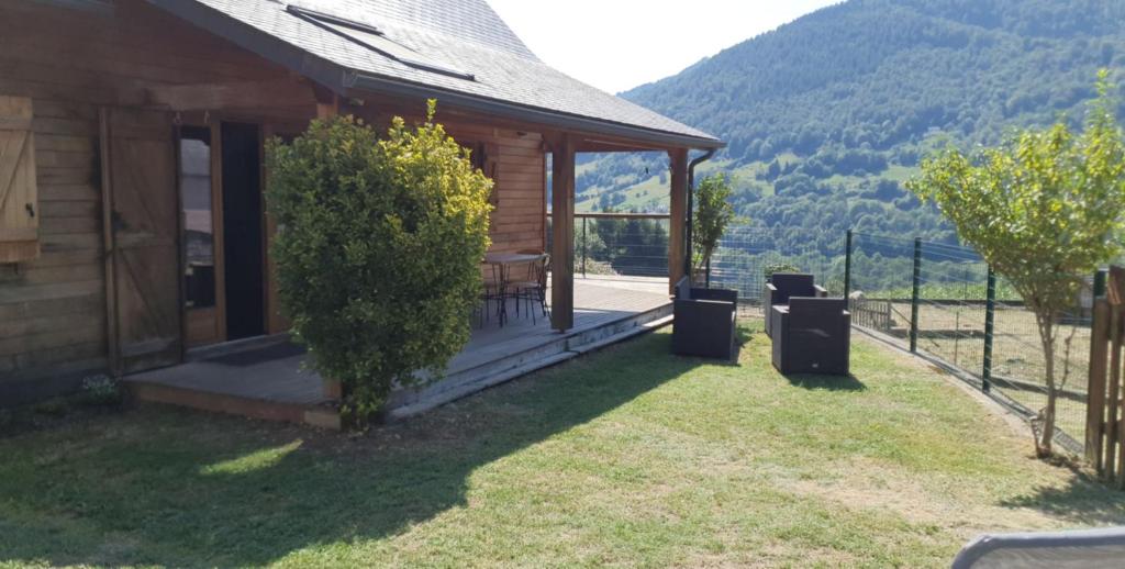 drewniany domek ze stołem i krzesłami na ganku w obiekcie Chalet au cœur du Val d'Azun w mieście Arras-en-Lavedan