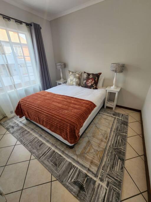 a bedroom with a bed with a large window at Elegant 2 bed apartment next to Gautrain Centurion in Centurion