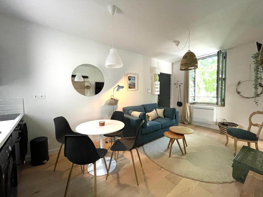 un salon avec un canapé, une table et des chaises dans l'établissement Avignon pedestrian area, charming, 4 persons, à Avignon