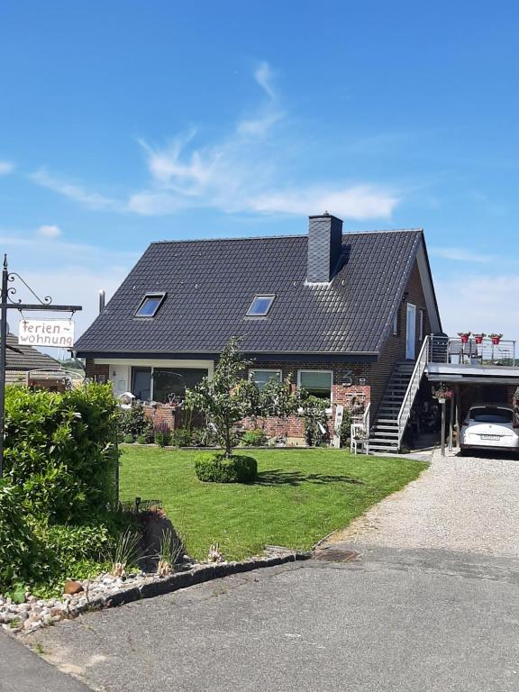 uma casa com um telhado preto e uma entrada em Haus Heimathafen em Süssau