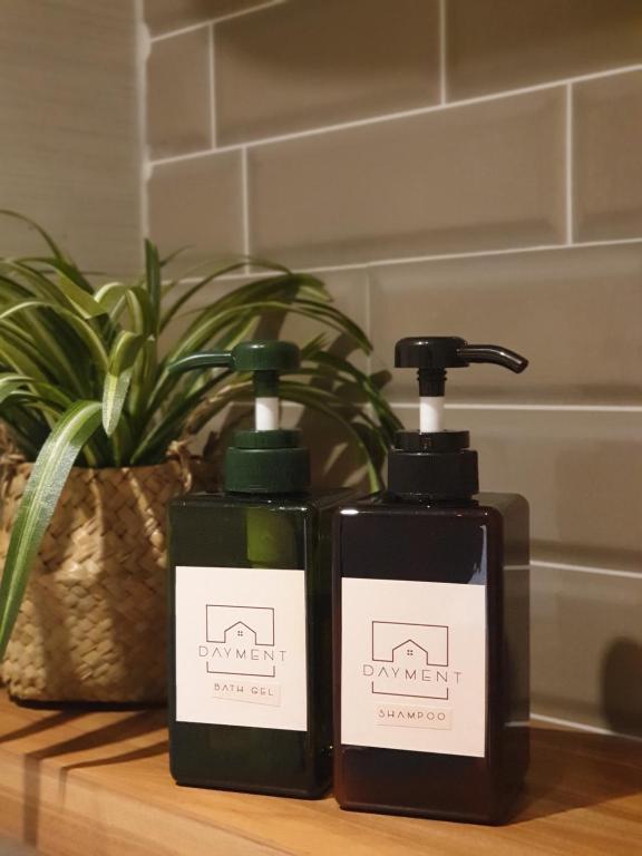two bottles of soap on a counter with a plant at R30 Apartemen Gateway Pasteur 2BR Daymentroom in Bandung