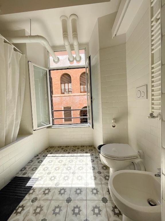 łazienka z 2 toaletami i oknem w obiekcie CAIROLI BOUTIQUE APARTMENT w Rzymie