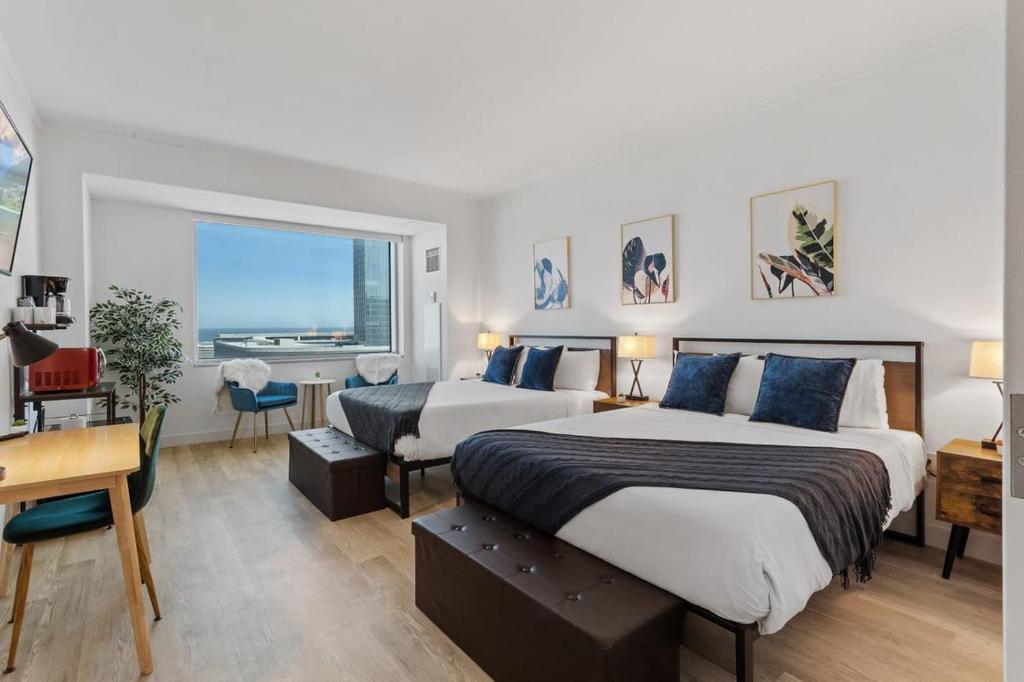 1 dormitorio con 2 camas, escritorio y ventana en Beachfront Double Queen - CozySuites en Atlantic City