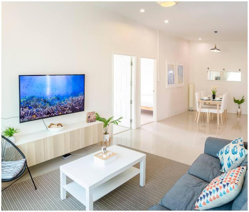 a living room with a couch and a tv on a wall at 2 bedroom apartment in Sukhothai