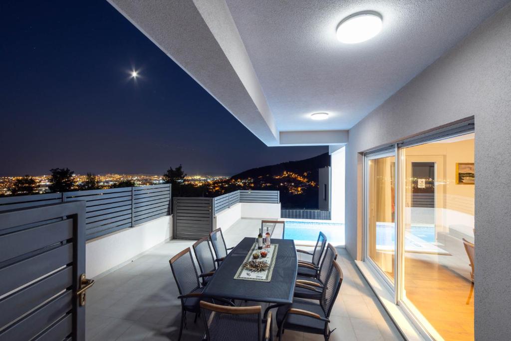 a dining room with a table and chairs on a balcony at Villa Dorso with heated pool in Klis