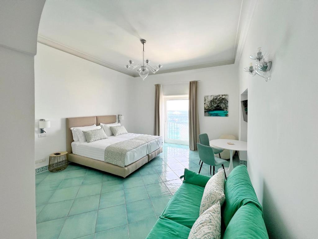 - une chambre avec un lit et un canapé vert dans l'établissement Casa Adelaide, à Capri