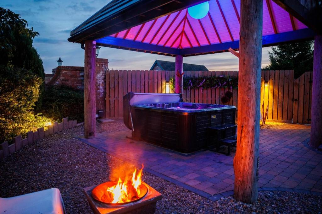 a hot tub in a backyard with a fire pit at Lincoln Holiday Retreat Lodge with Private Hot Tub in Lincoln