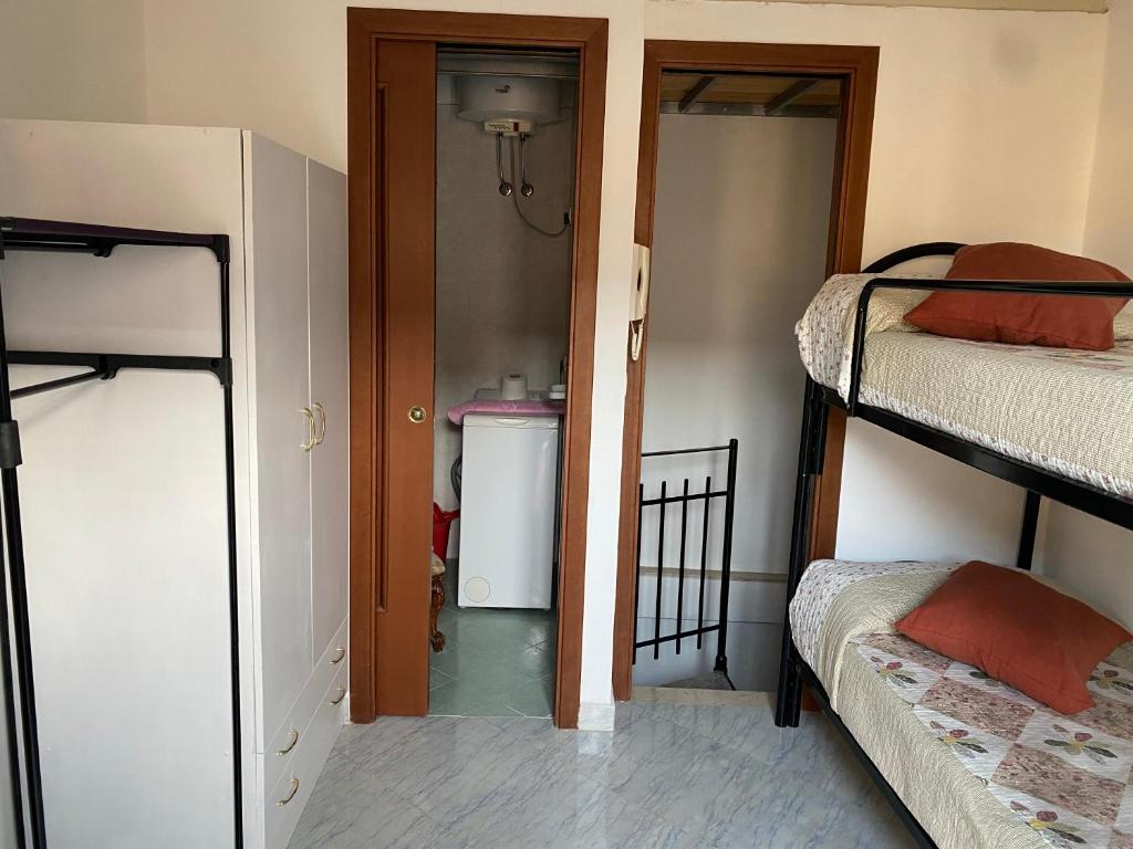 a room with two bunk beds and a closet at La Casetta In Centro - Holiday House in Scilla