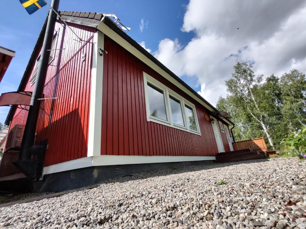 una cabaña roja y blanca sobre una pila de grava en Villa Stolle en Hammarstrand