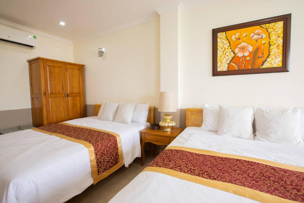 胡志明市的住宿－霍安明星酒店，酒店客房设有两张床,墙上挂着一张照片。