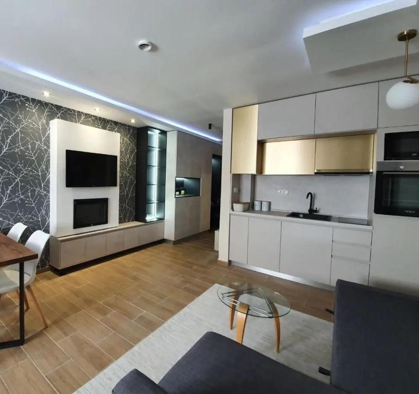 a large kitchen with white cabinets and a table at Apartman Skyline Kopaonik in Kopaonik