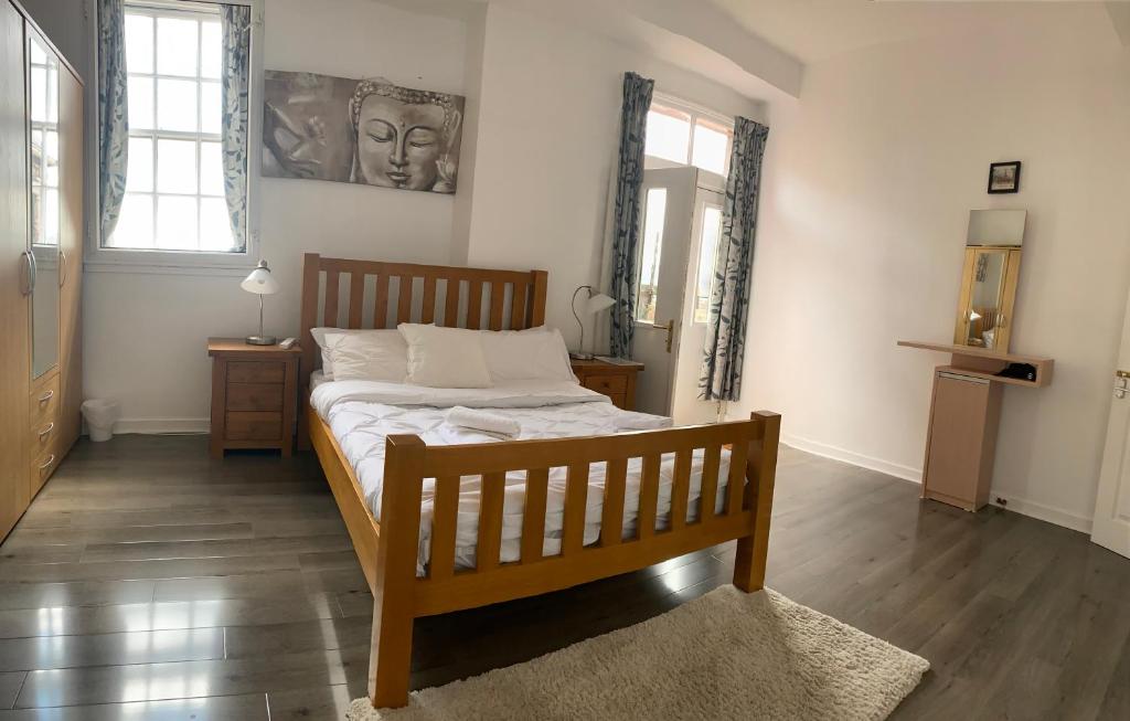 - une chambre avec un lit en bois et 2 fenêtres dans l'établissement Old Town View Apartment, à Édimbourg